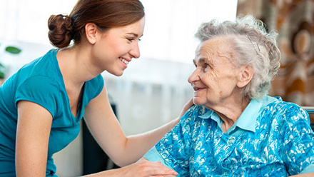Elderly woman receiving care from a young woman